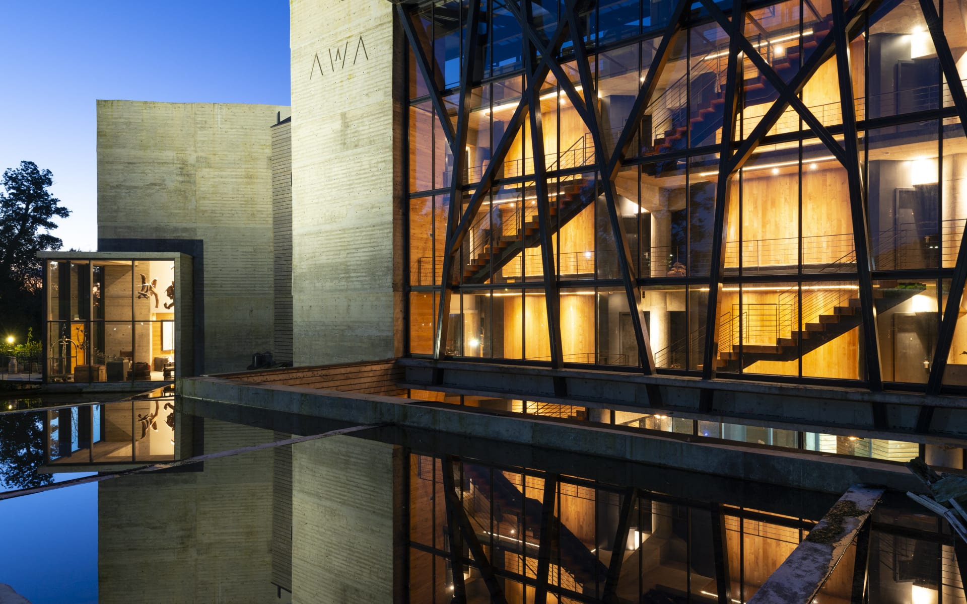 Hotel AWA's exterior is illuminated by light at night.