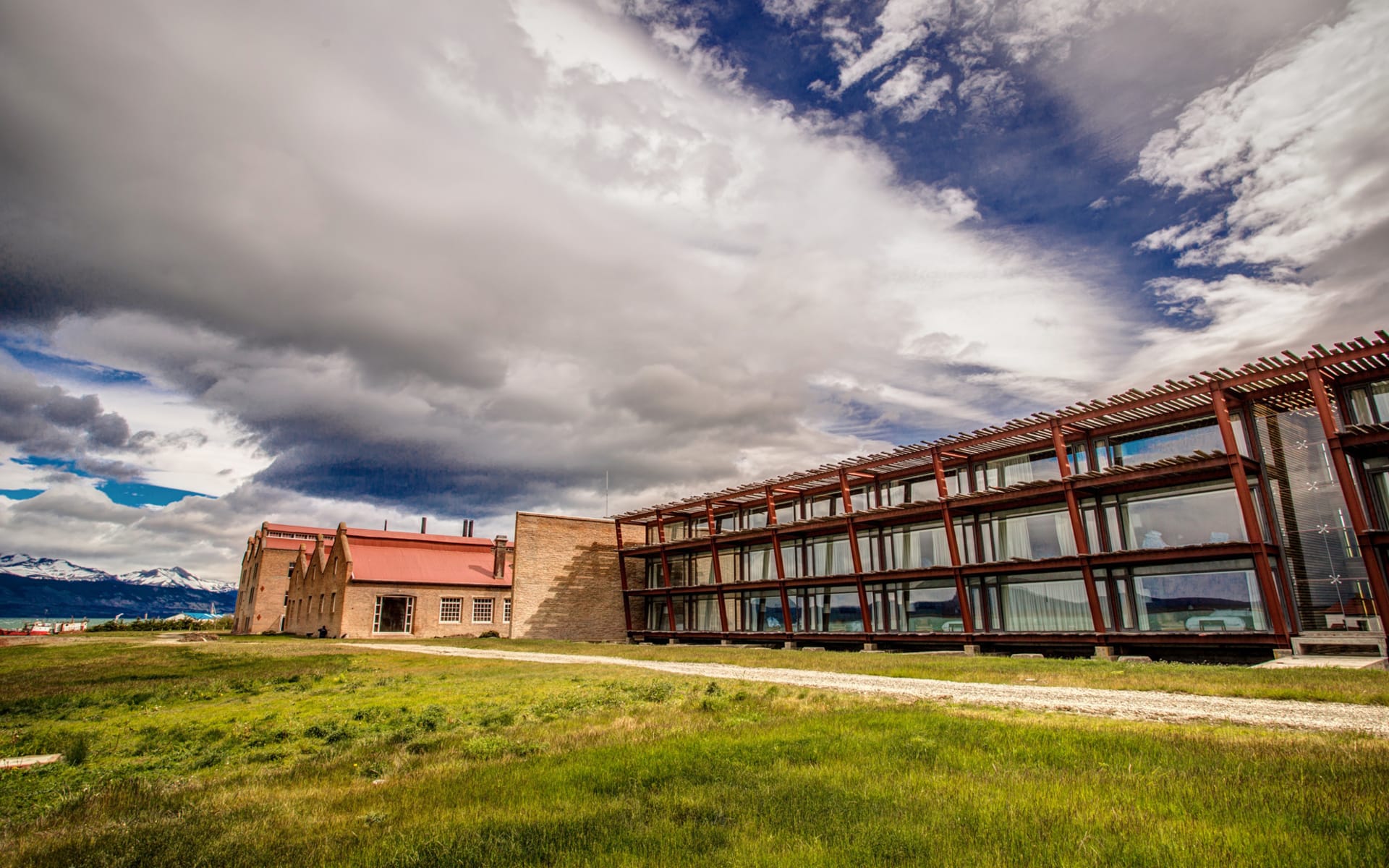The Singular Patagonia hotel has a large green lawn in front of the building. 