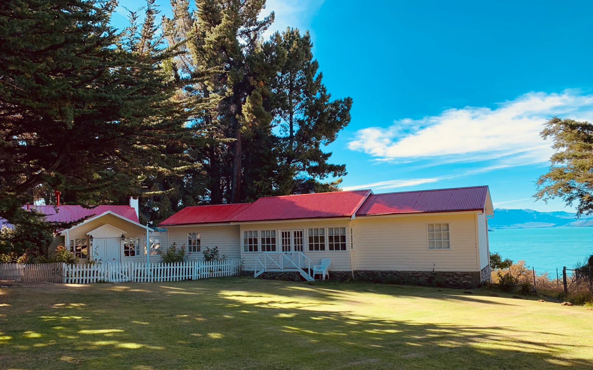 The exterior of the estancia is dressed in white wood-panelling with a red roof. 