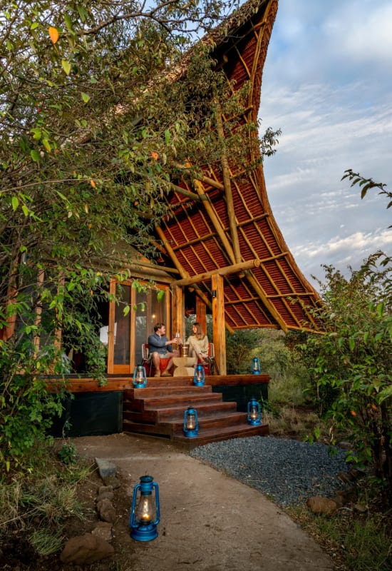 a couple sit on a private veranda, enjoying a private dining experience during a sunny day.