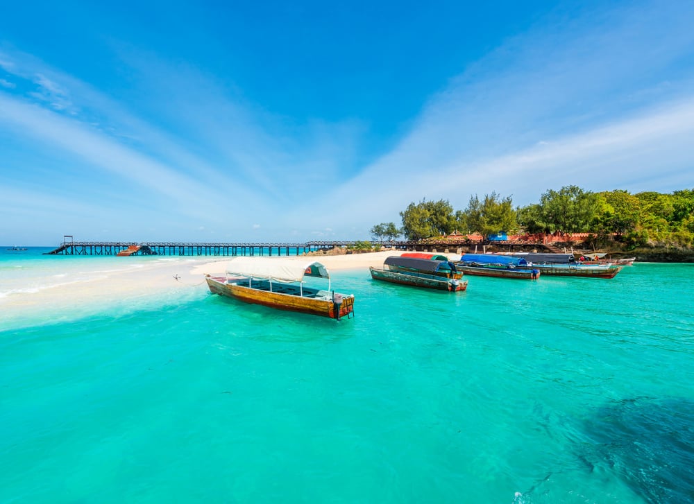 Traditional boats sit at a beach in Zanzibar.