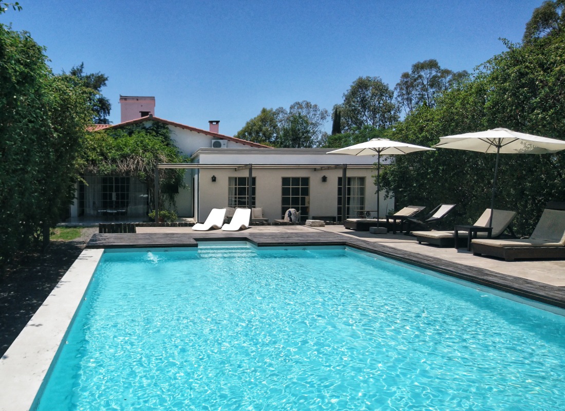 The swimming pool at Finca Valentina is rectangular shape, with sun loungers and white umbrellas circling it. 