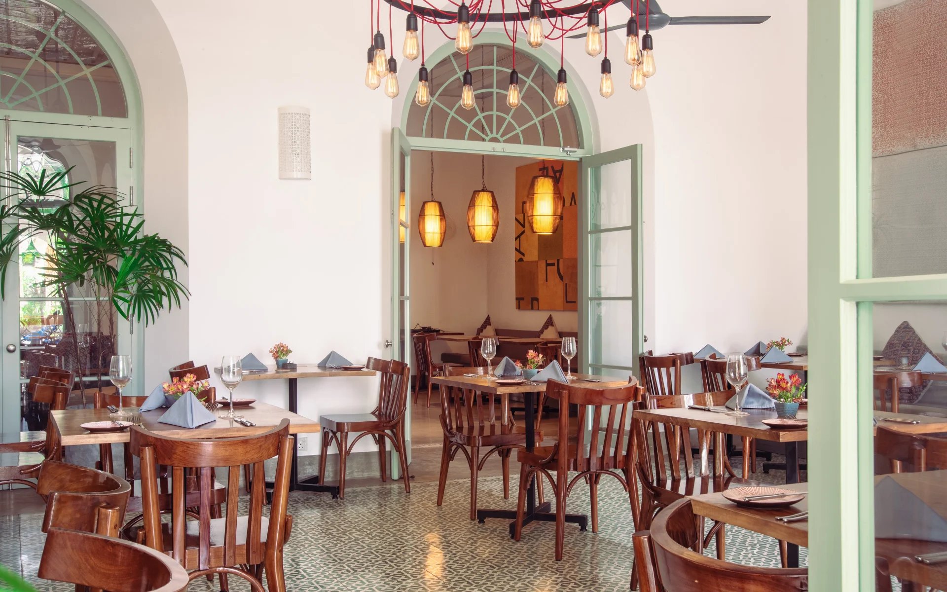 the hotel restaurant has a bright and airy ambience, dressed in wooden furnishings and with a large chandelier.