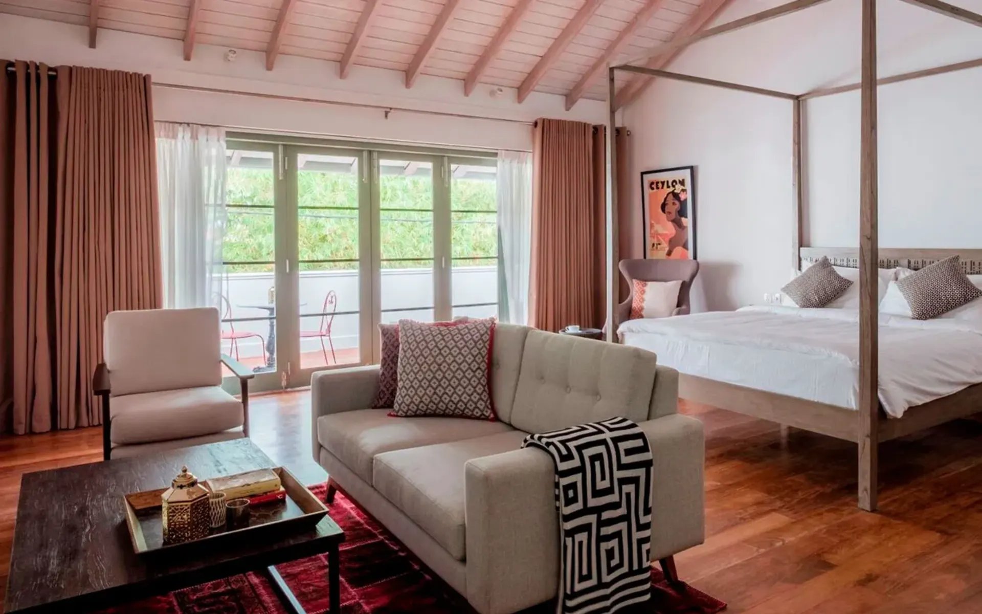 One of the bedrooms has wood panelled floors and a king-sized four-poster bed, with large sliding doors which lead onto a balcony.