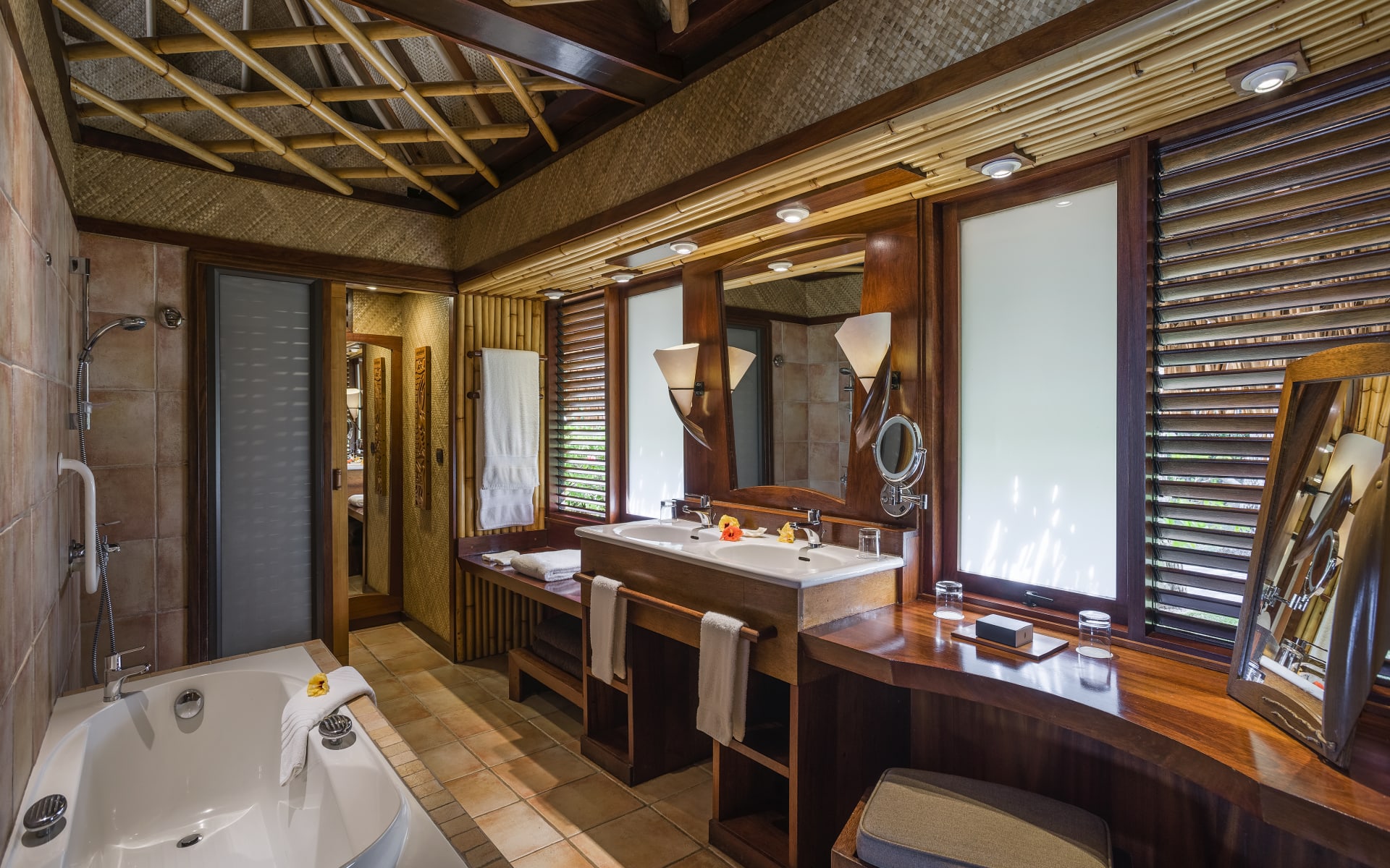 The bathroom has a tub, a lark sink and a vanity table.