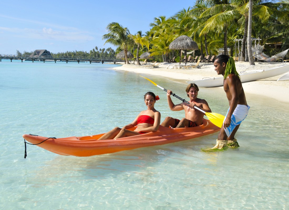 A couple are sitting in a kayak. 