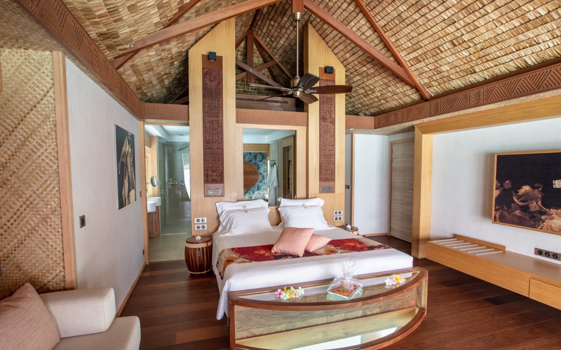 The bedroom has a large bed with a sofa. 