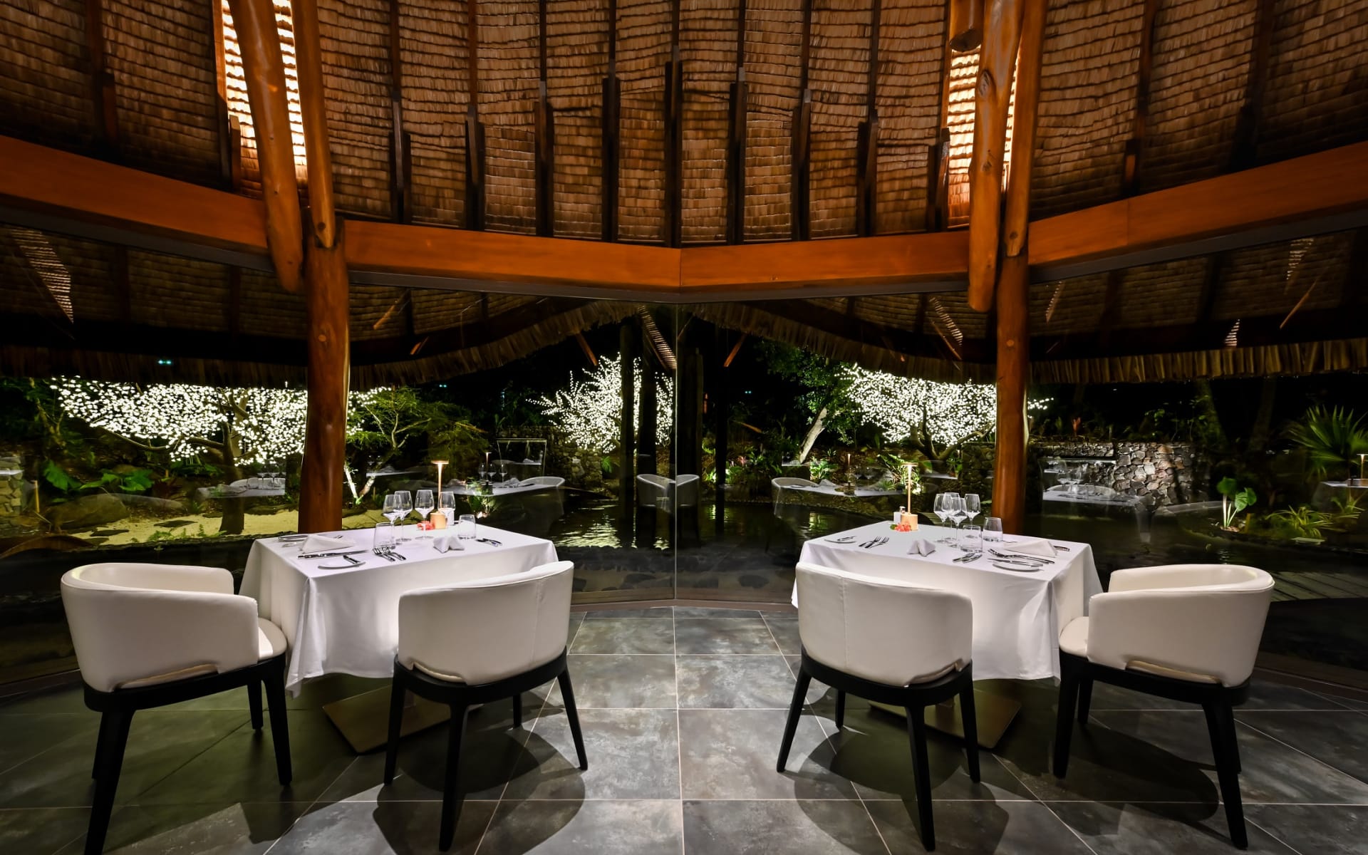 There are two dining tables set up for dinner. 
