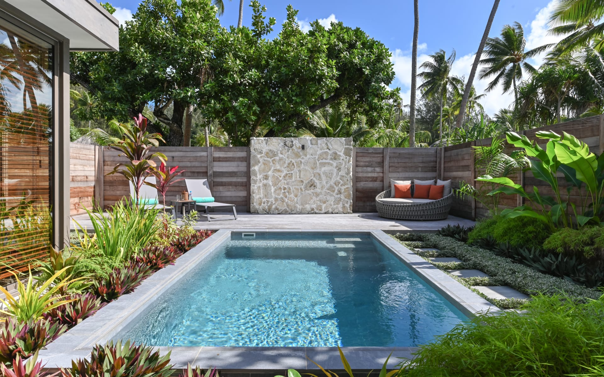 A swimming pool is surrounded by plants. 