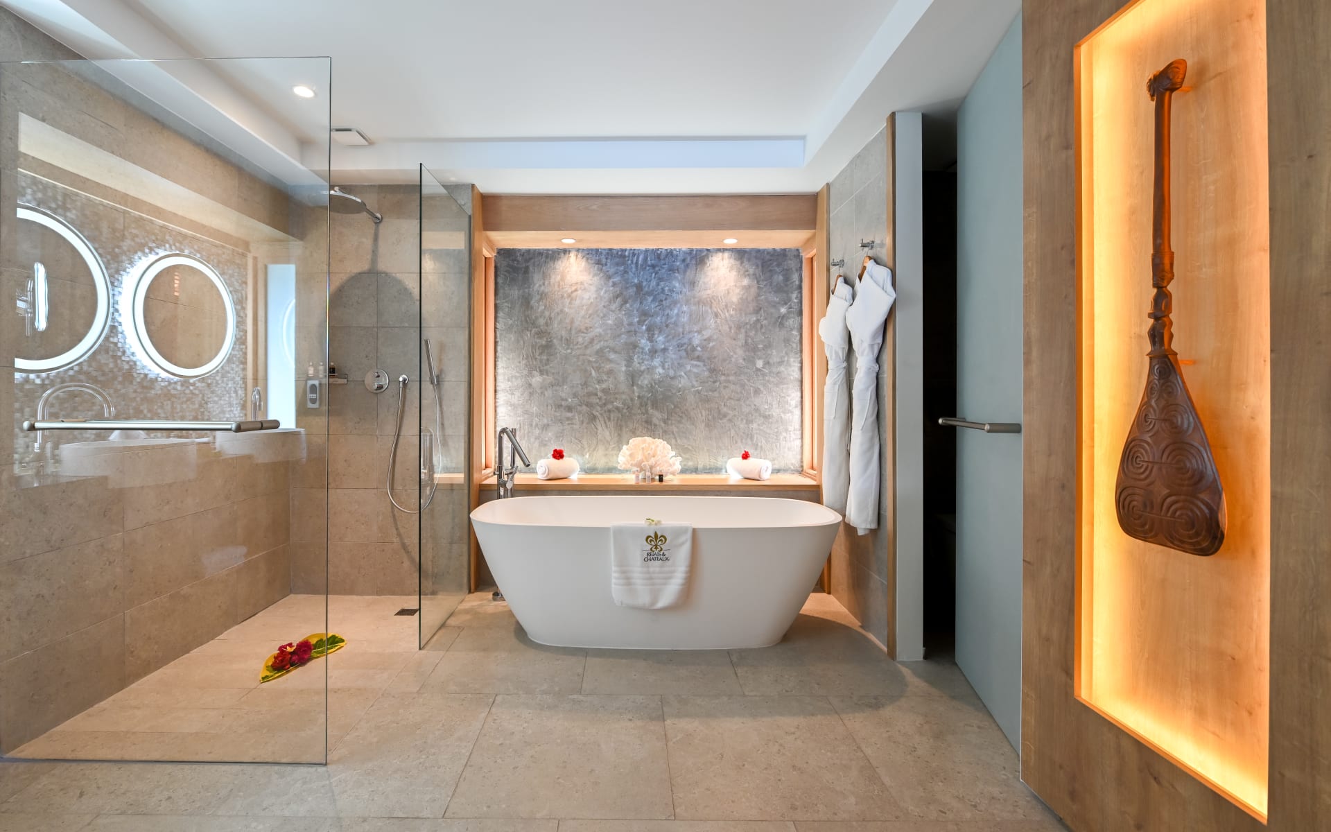 A rolltop bathtub sits next to a walk-in shower. 