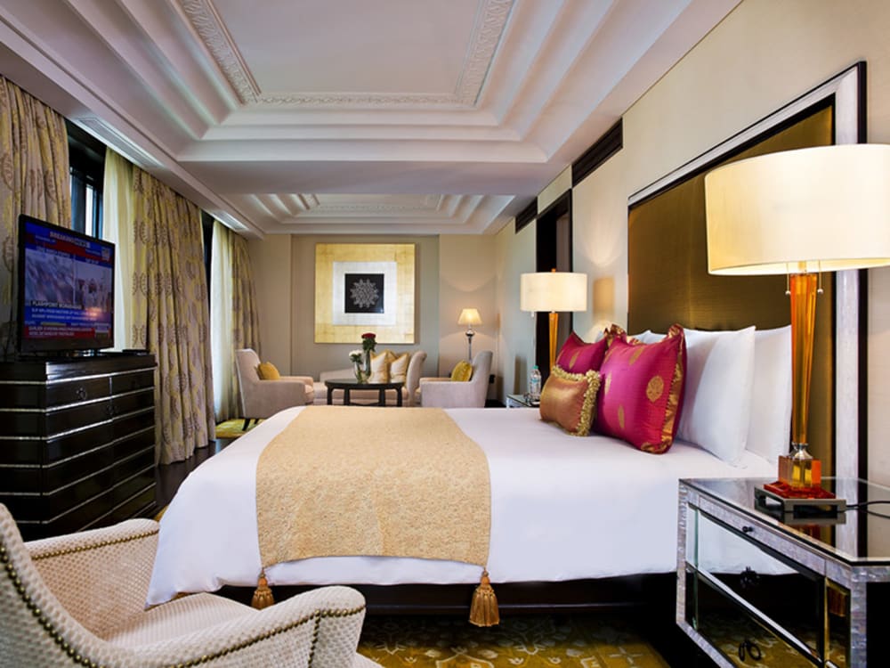 A bedroom with a TV and seating area