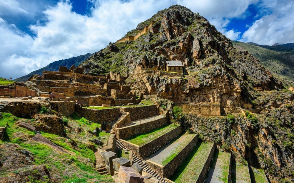 The iconic Machu Picchu in Peru has incredible stone ruins surrounded by grass.