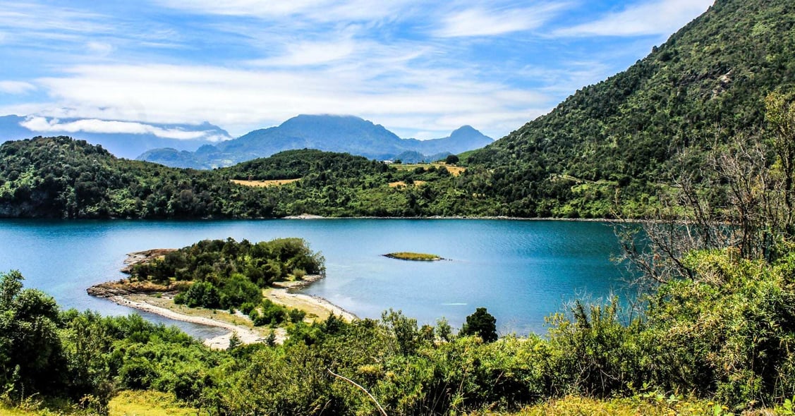 A spectacular landscape in Chile has mountains surrounded by vegetation.