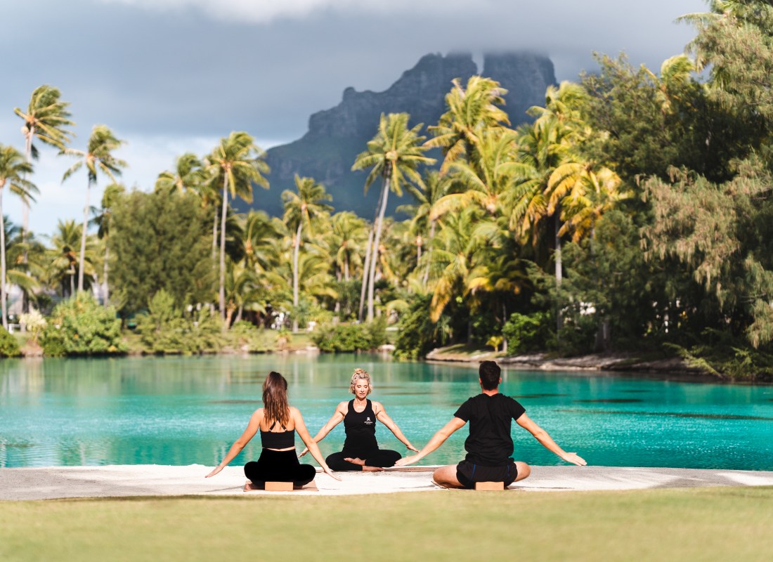 Couples yoga next to lagoon