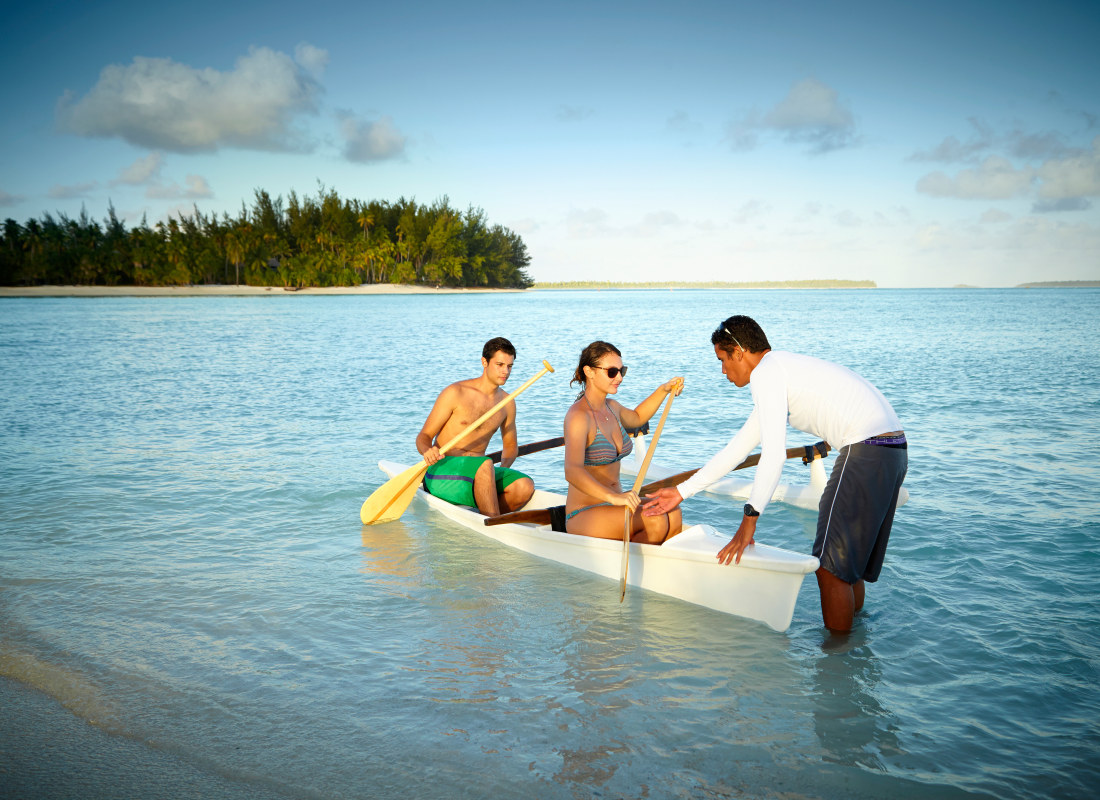 Couple in traditional canoe in ocean 