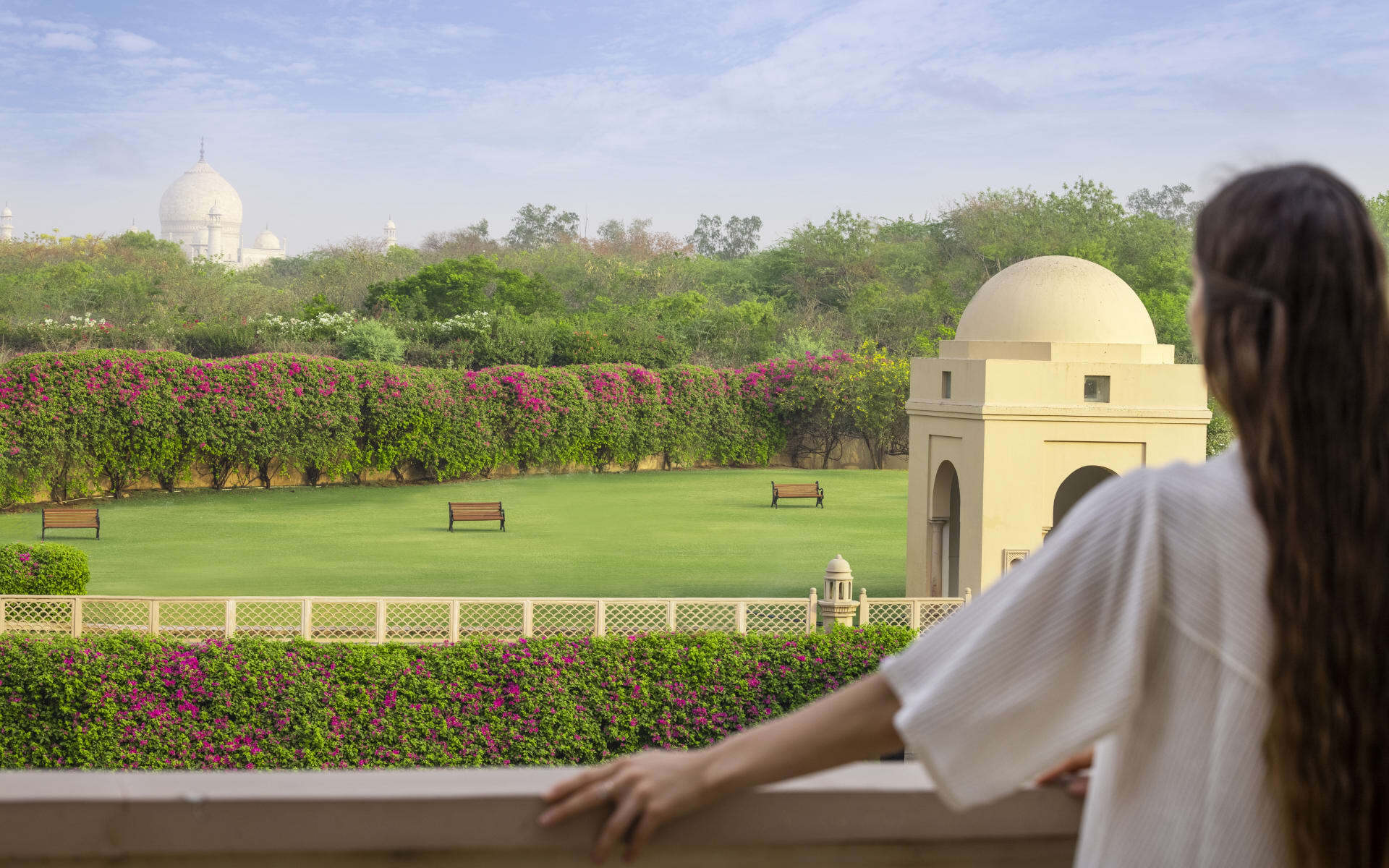 A woman looks over the landscaped gardens at the Oberoi Amarvilas.