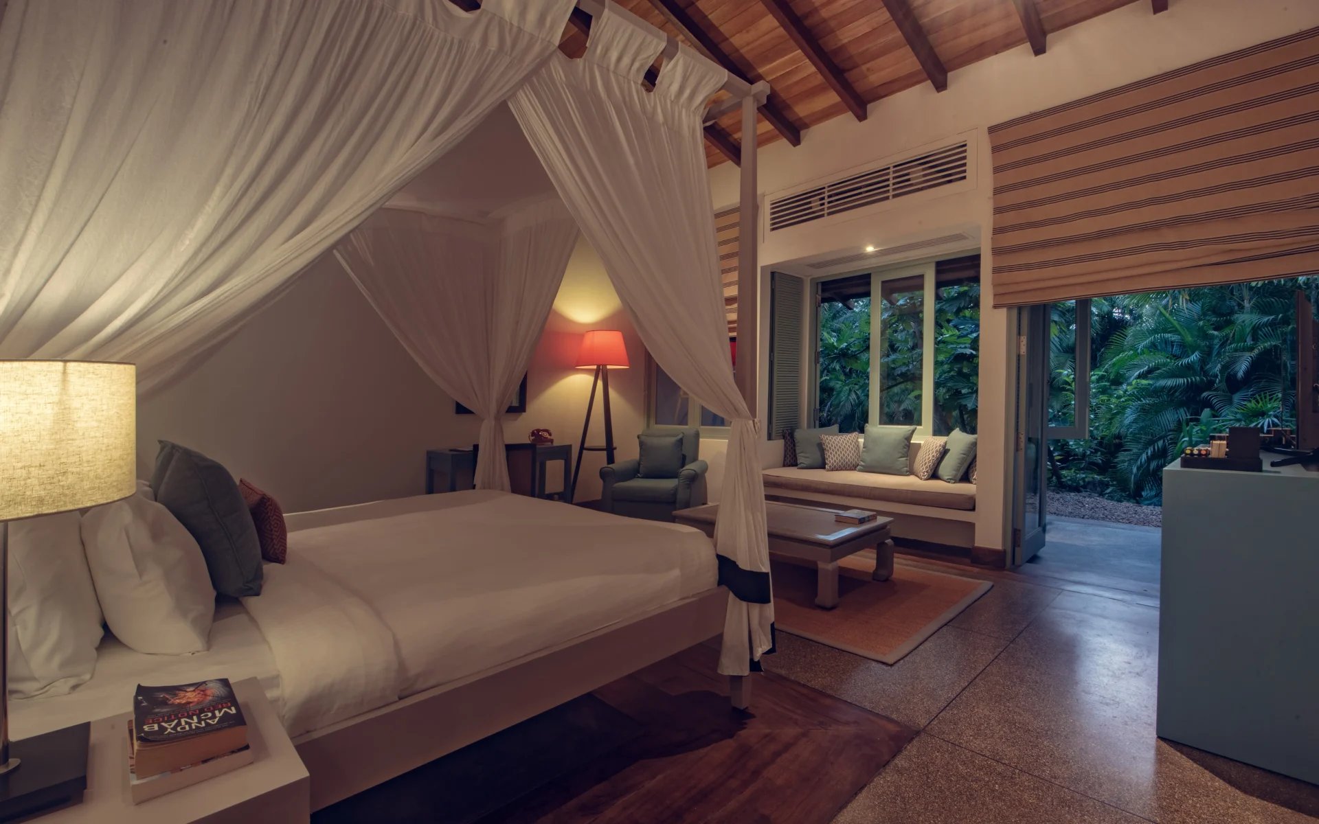 One of the bedrooms is adorned in hardwood furnishings, including a four-poster bed dressed in white linen sheets.