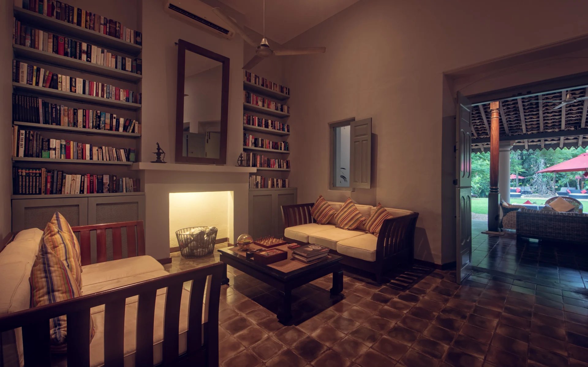 The communal library at the Wallawwa is warmly lit and equipped with comfy sofas and a large bookshelf.