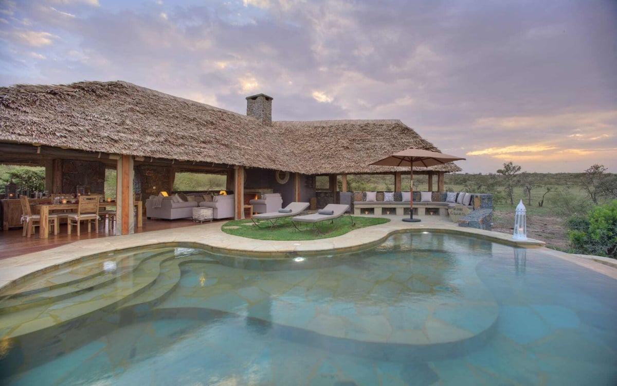 Naboisho Camp has an infinity pool facing a violet sunset.