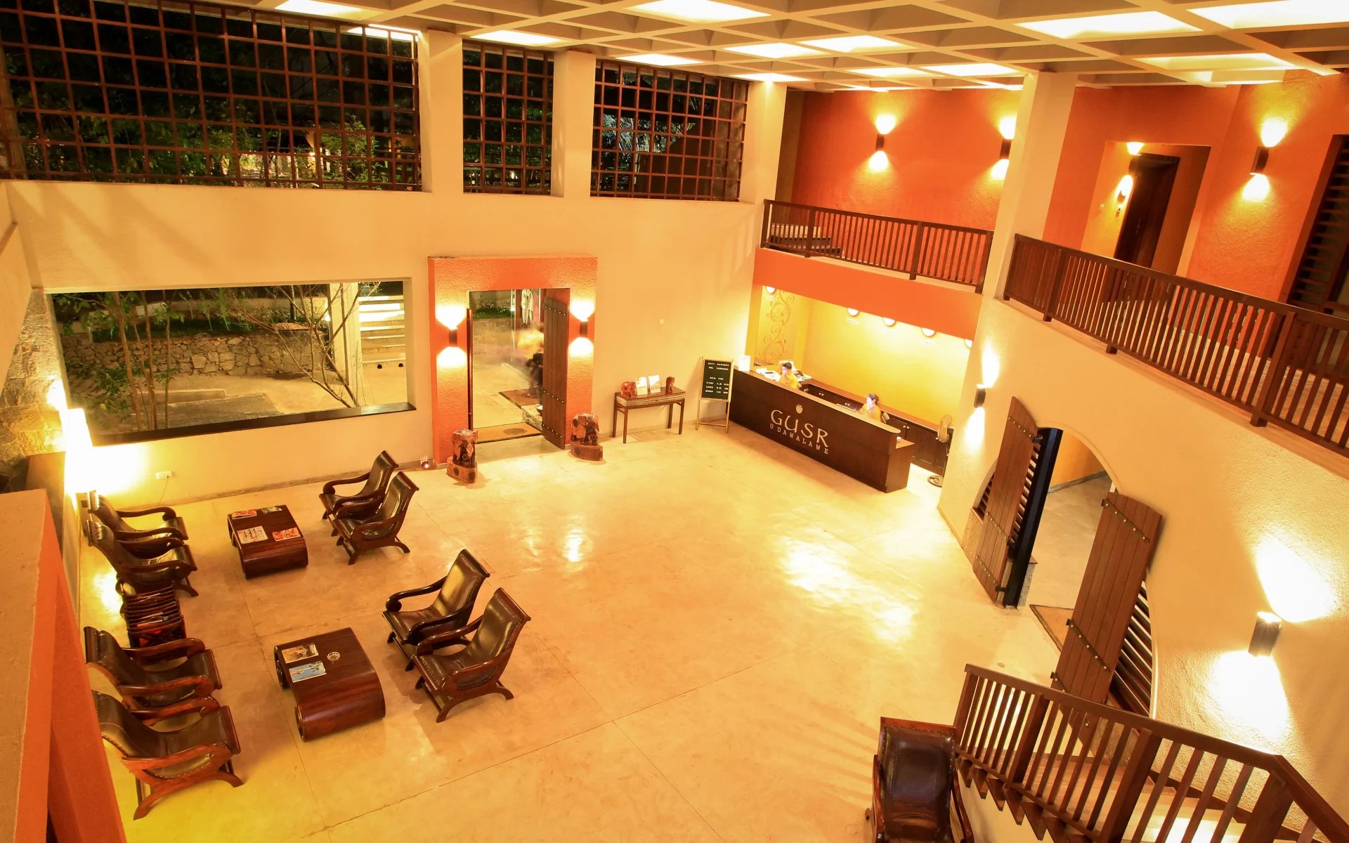 The grand lobby is warmly-lit and spacious, equipped with comfy seating and completed by glossy flooring.