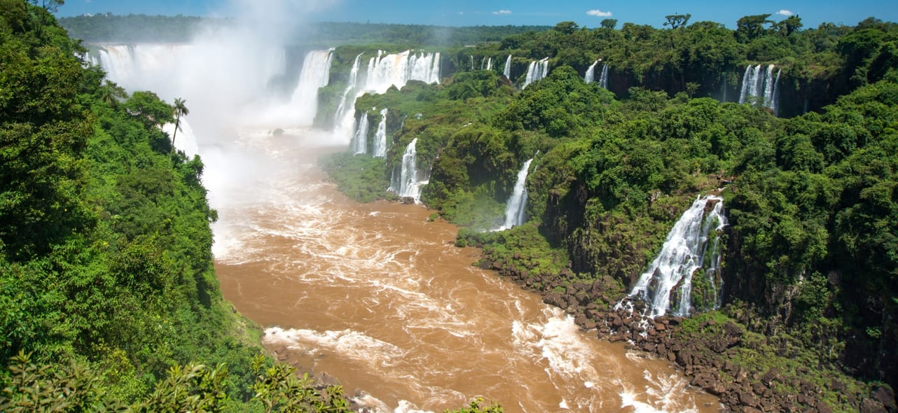 Iguazu Falls, captured by Ondrej Bocek, featuring a dramatic view of the cascading waterfalls and lush surrounding rainforest