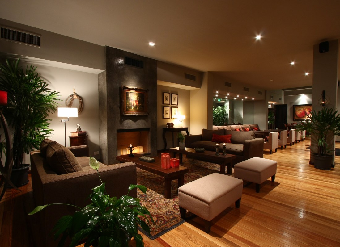 The lounge at Legado Mitico has wooden floors, inside plants, a stone fireplace and wooden tables and sofas.