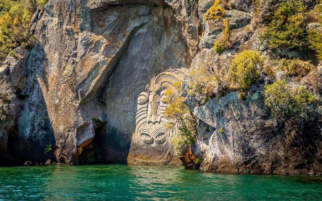 A traditional Maori carving is interwoven into Lake Taupo, fronted by waters.