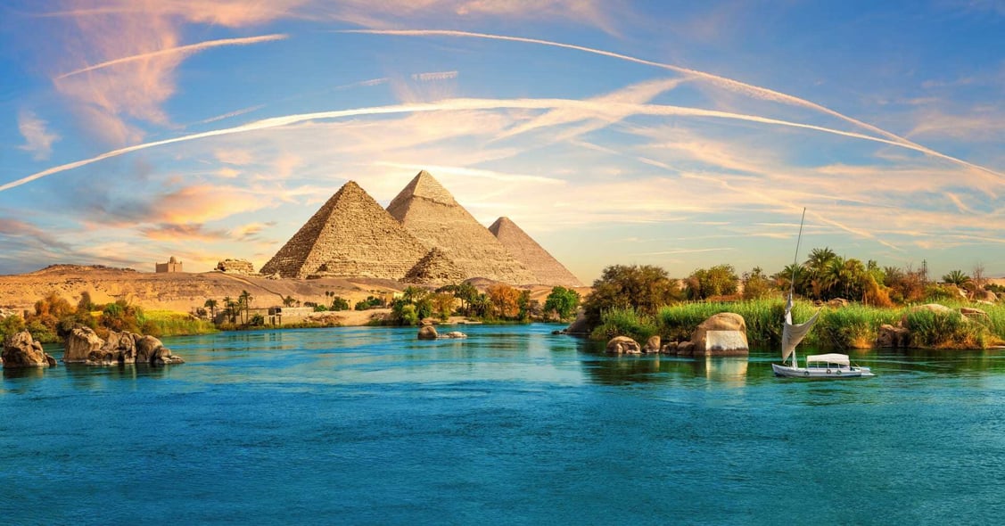 The pyramids dazzle ahead of a lilac sunset