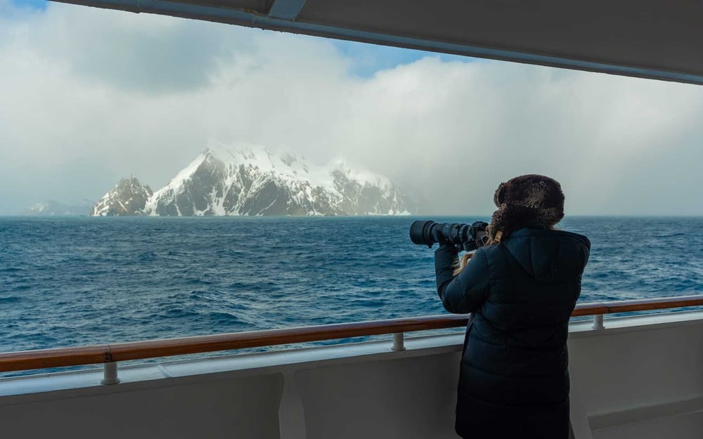 Someone takes photographs from a cruise ship in Antarctica.