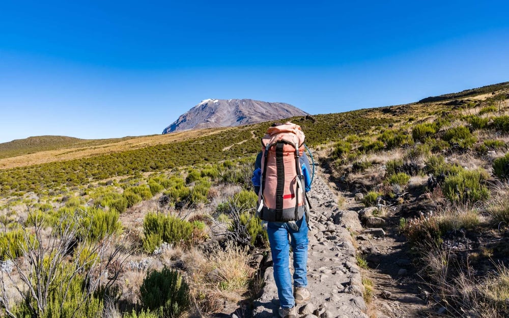 People trek with backpacks at Mount Kilimanjaro.