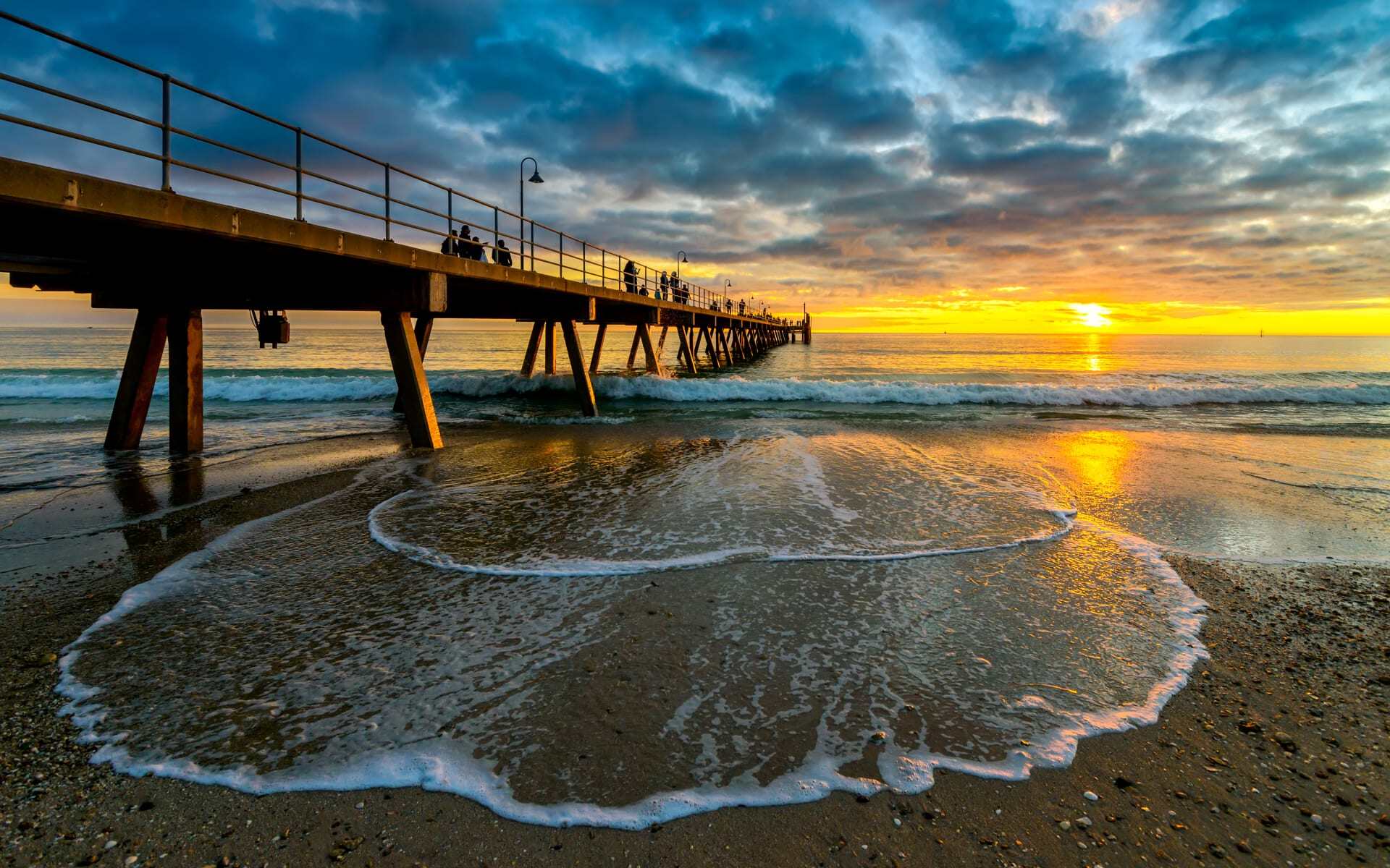 People enjoy the sunset from the Glenelg Beach Jetty in Adelaide.