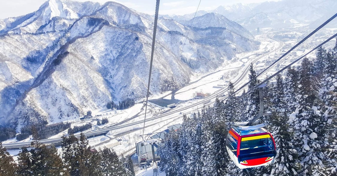 A cable car descends the snowy mountains of Japan during peak season.