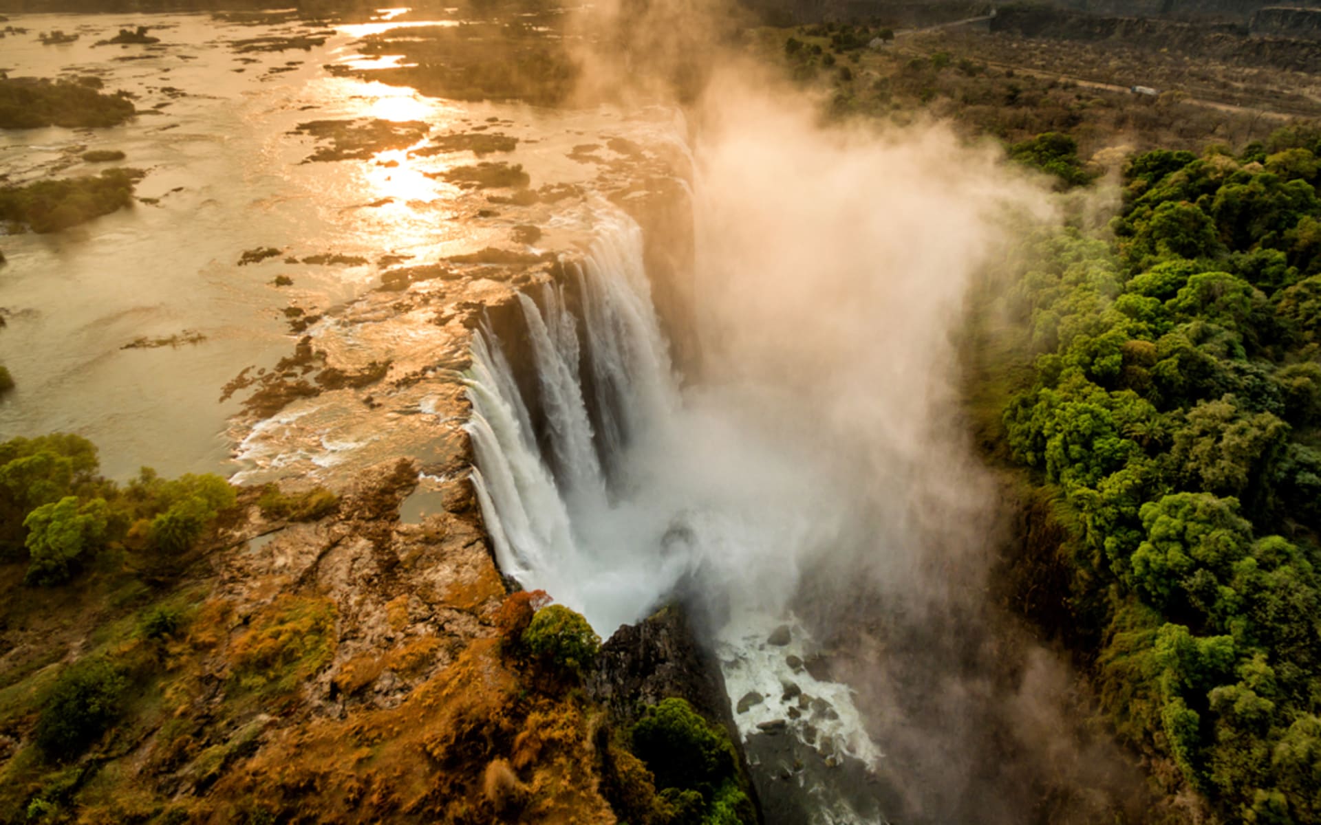 Victoria Fall has cascades of water rising in a mist.