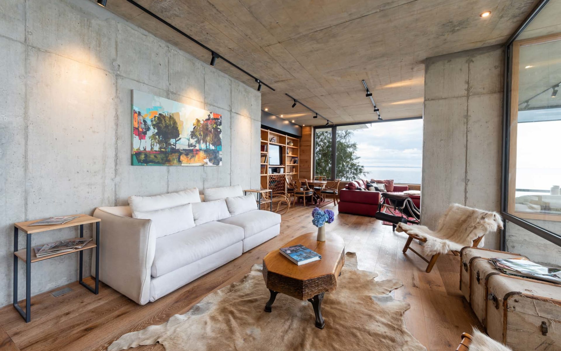 Hotel AWA's private villas have a lounge with a long sofa, arm chairs and a bookcase filled with books. 