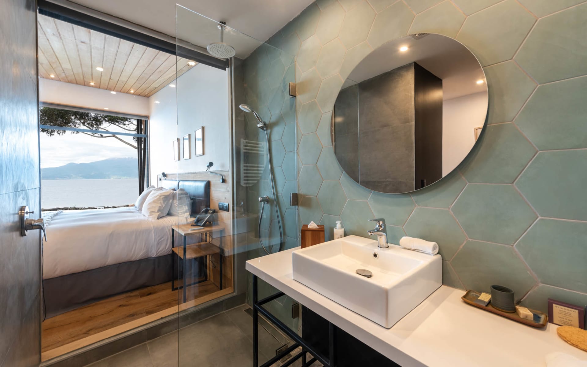 A double bed overlooks the water and has an open-plan space with the bathroom.