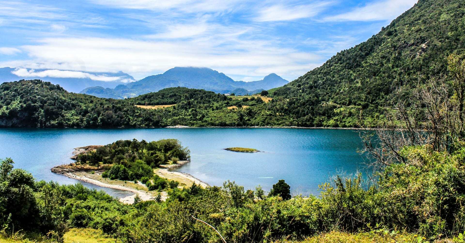 A spectacular landscape in Chile has mountains surrounded by vegetation.