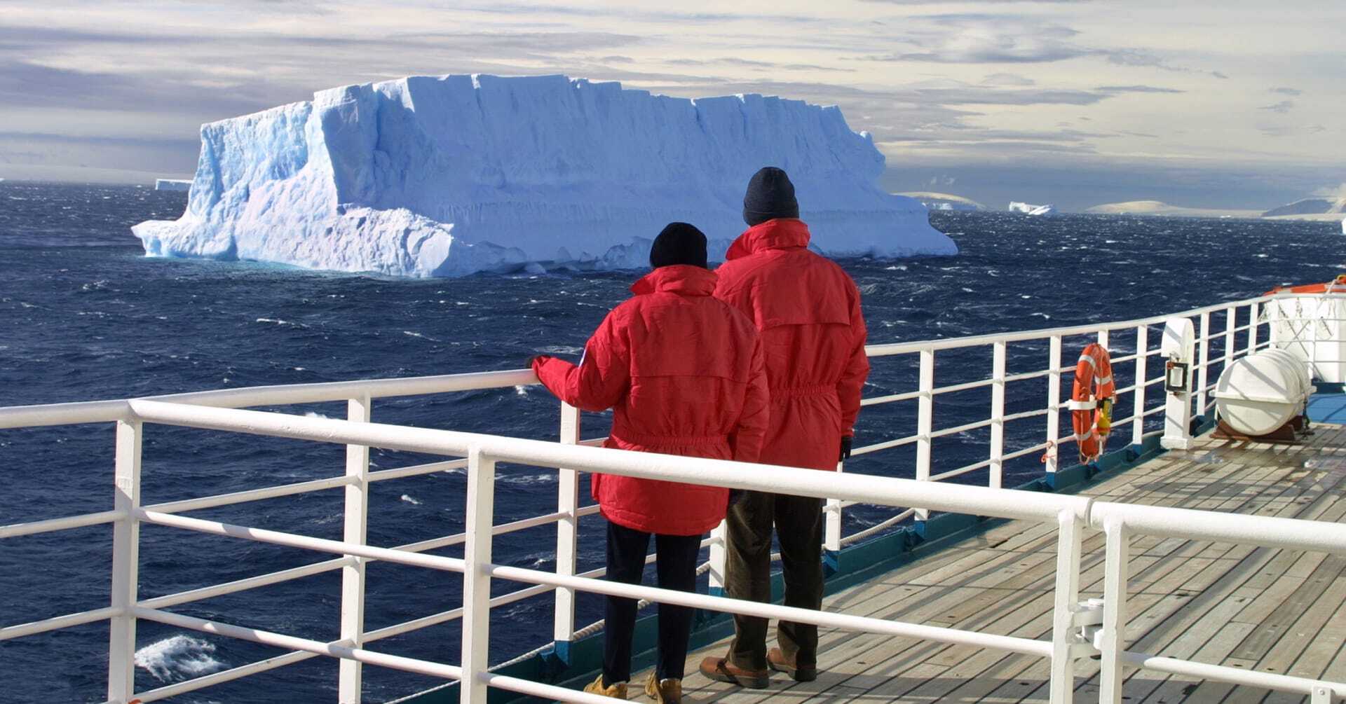 A couple look out at the waters of Antarctica.